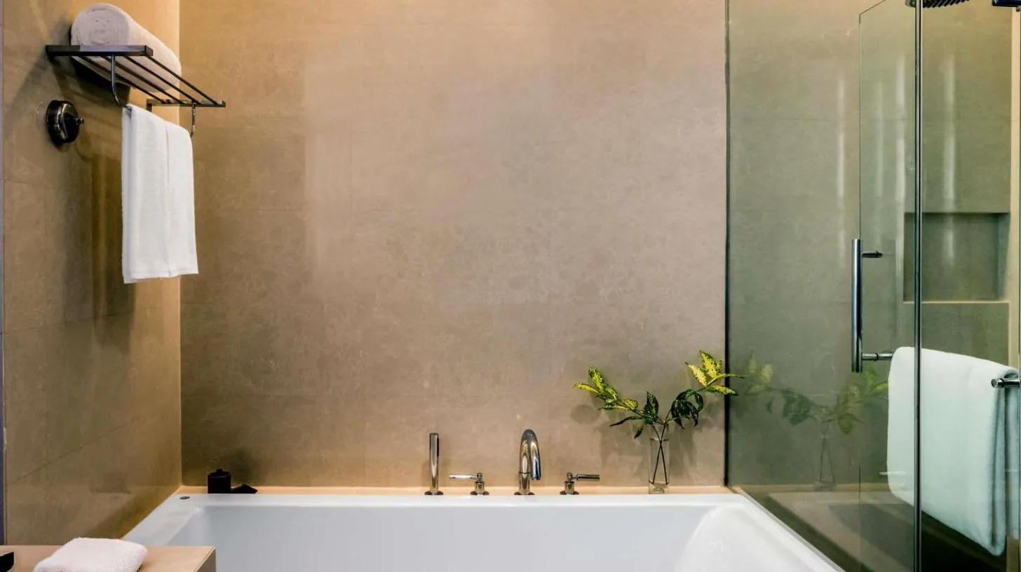 une salle de bain avec une baignoire blanche et une douche au Pullman Bangkok King Power Ã  Bangkok
