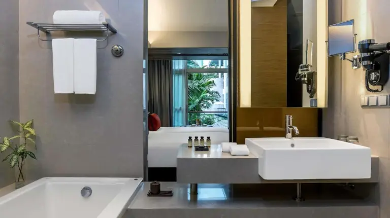 une salle de bain avec un lavabo, une baignoire et un miroir au Pullman Bangkok King Power Ã  Bangkok