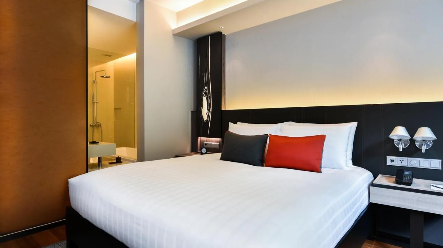 une chambre avec un grand lit blanc avec des oreillers rouges au Pullman Bangkok King Power Ã  Bangkok
