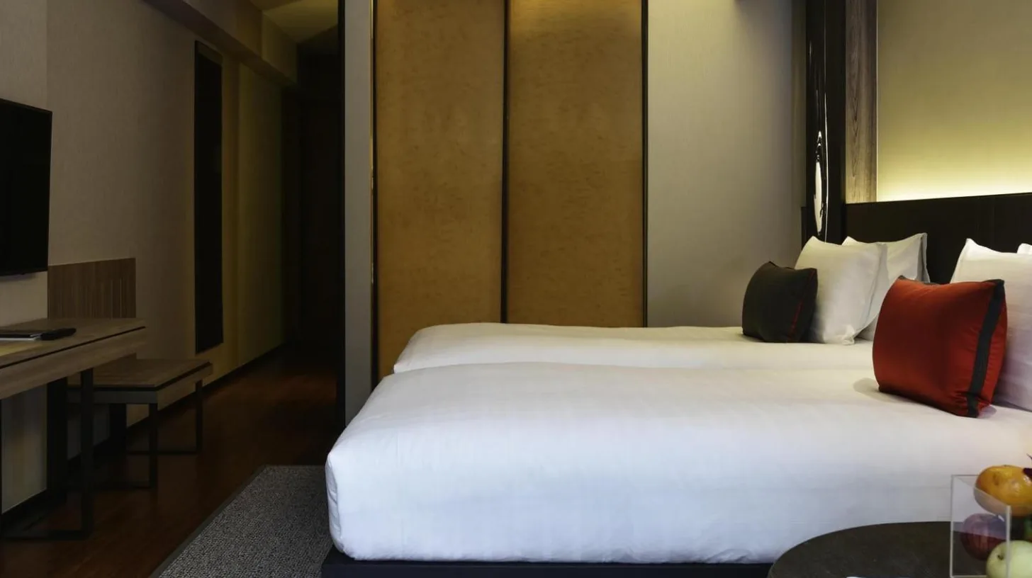 une chambre d'hÃ´tel avec un grand lit et une table au Pullman Bangkok King Power Ã  Bangkok