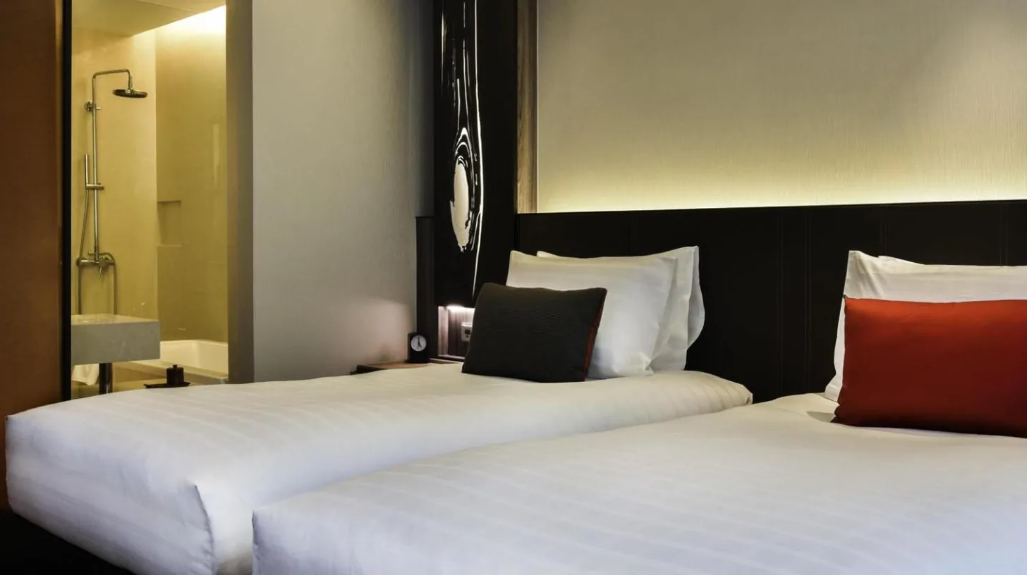 deux lits cÃ´te Ã  cÃ´te dans une chambre au Pullman Bangkok King Power Ã  Bangkok