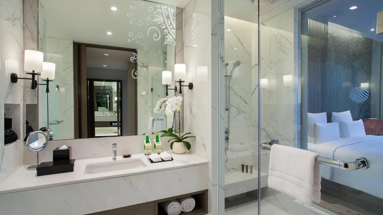 un dormitorio con una gran cama blanca y un baÃ±o en Pullman Ciawi Vimala Hills Resort en Bogor