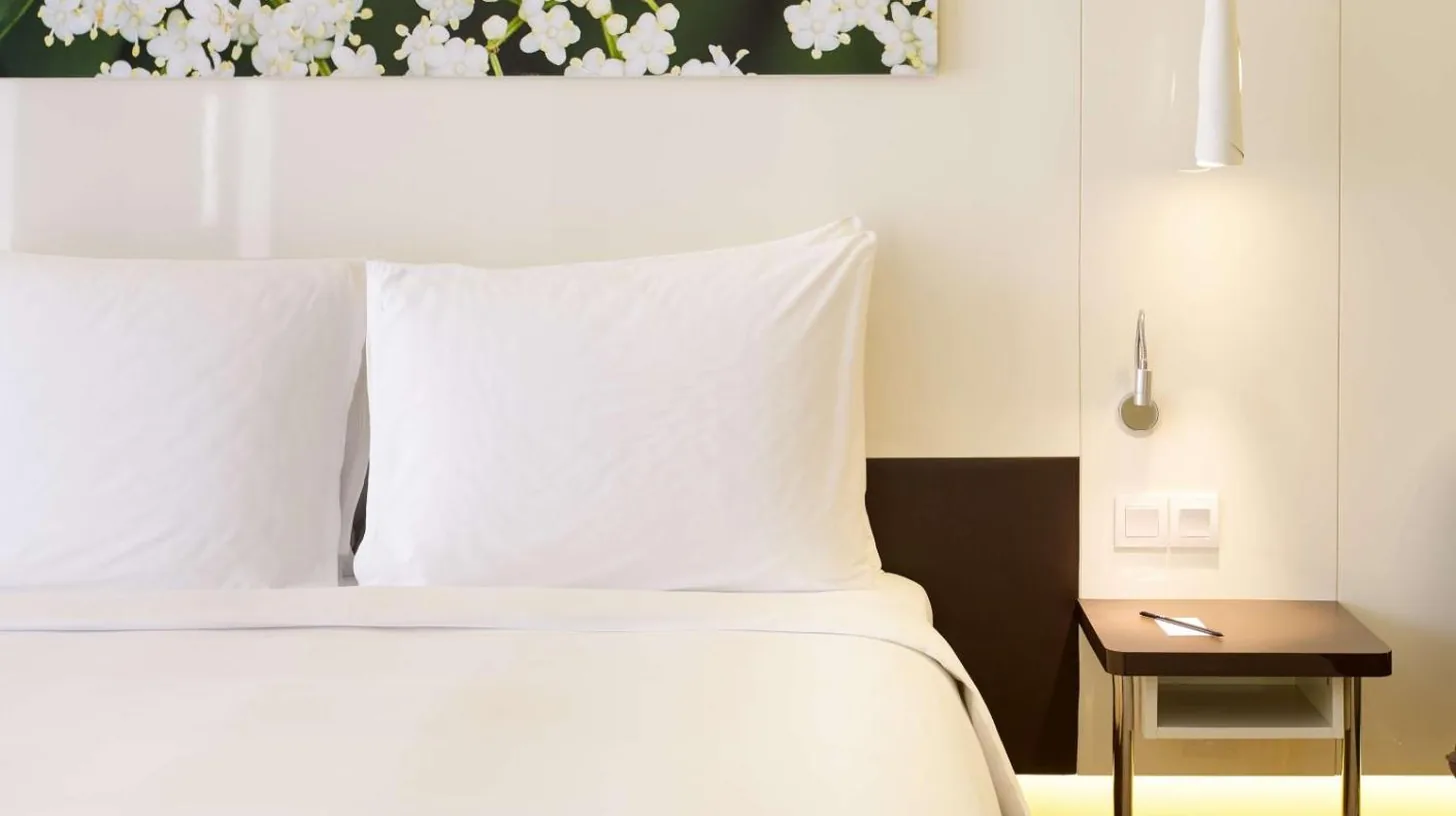 a bedroom with a bed with white pillows and a table at Radisson Blu Hotel & Convention Centre Kigali in Kigali