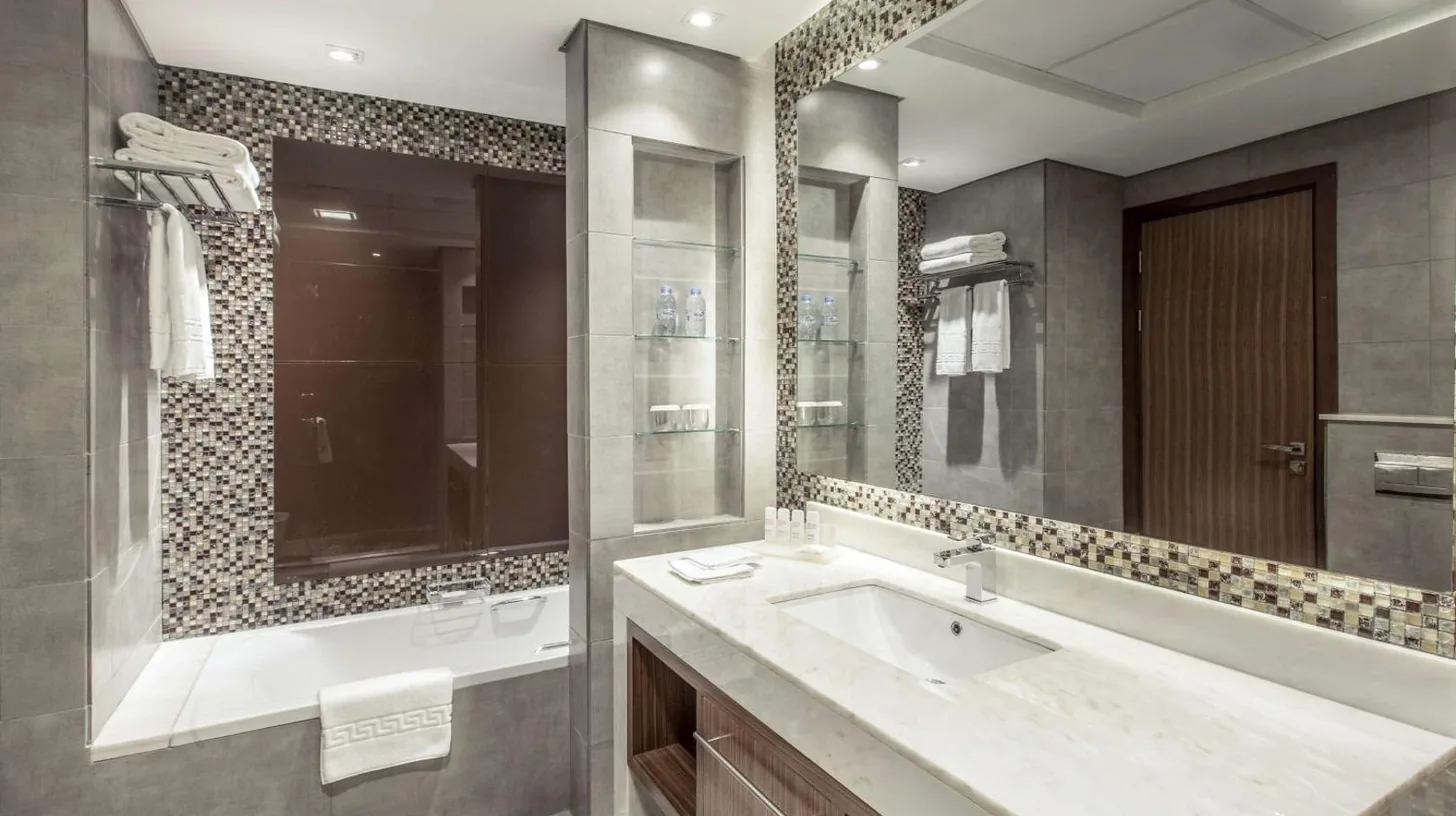 un dormitorio con una gran cama blanca y un escritorio en Radisson Blu Hotel