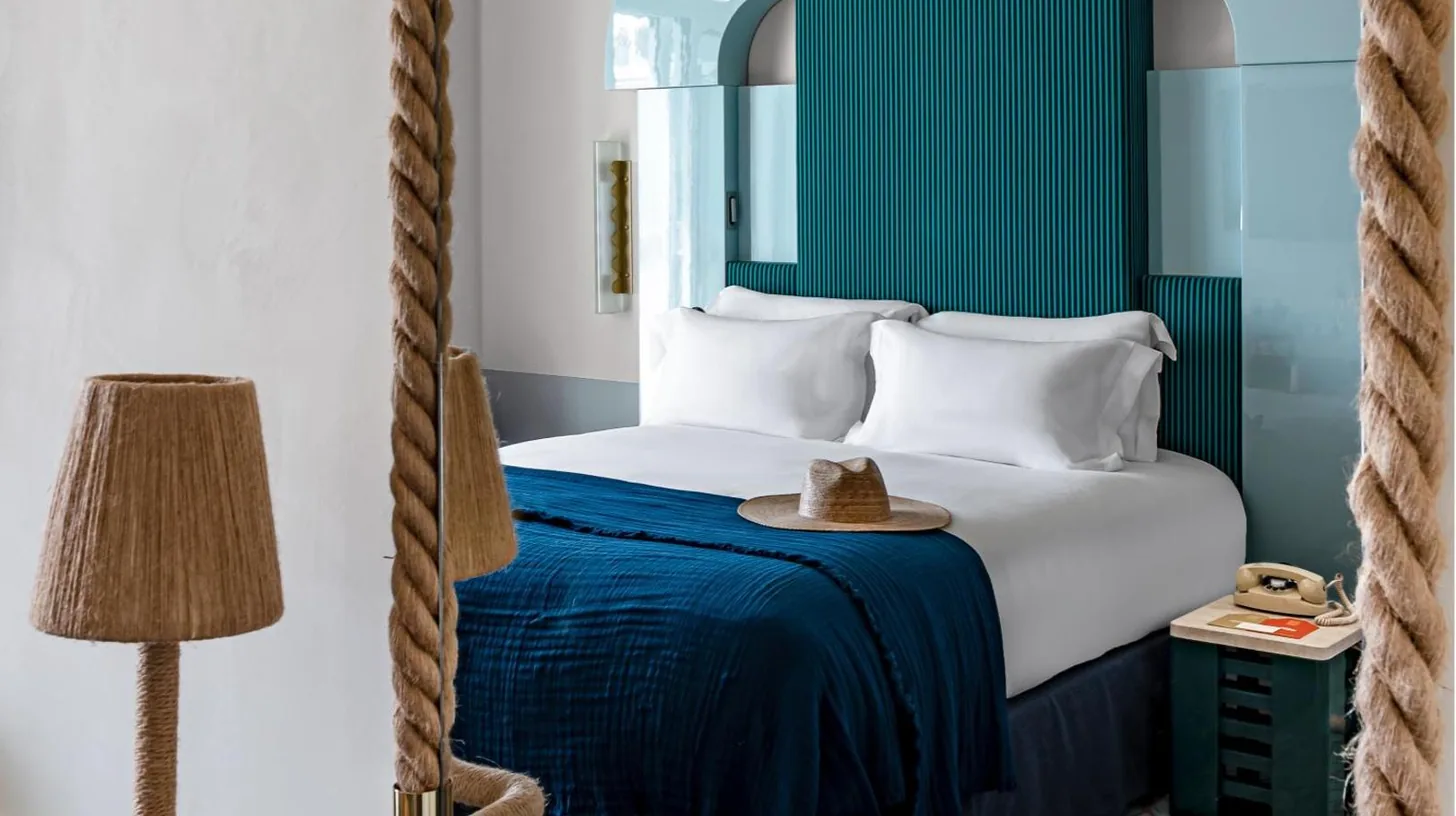 a hotel room with a bed with a hat on it at Regina Experimental Biarritz in Biarritz