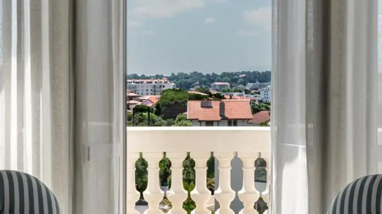 a living room with two chairs and a large window at Regina Experimental Biarritz in Biarritz