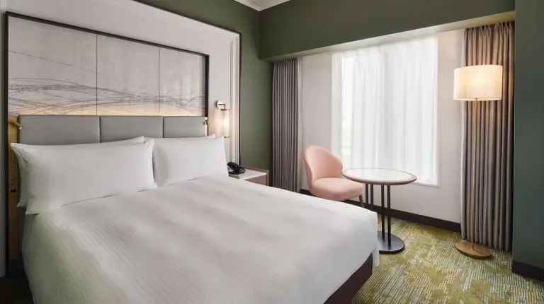 ein Schlafzimmer mit einem weiÃen Bett und einer grÃ¼nen Wand im RIHGA Royal Hotel Osaka