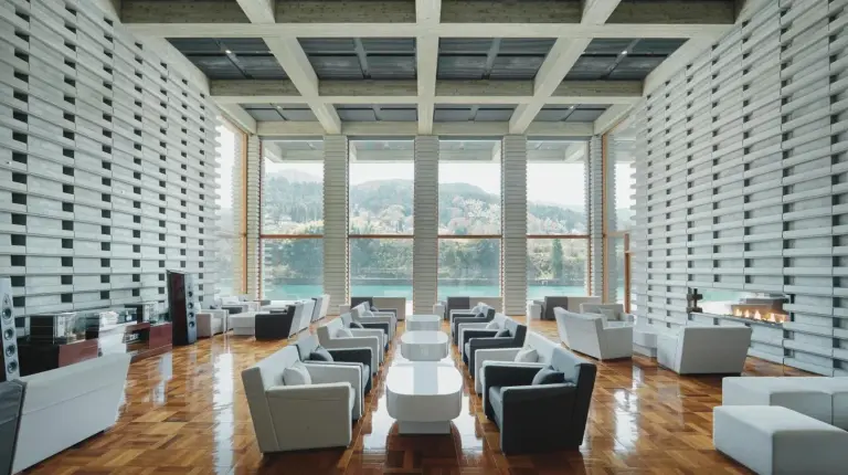 a large room with white chairs and tables and windows at River Retreat Garaku in Toyama