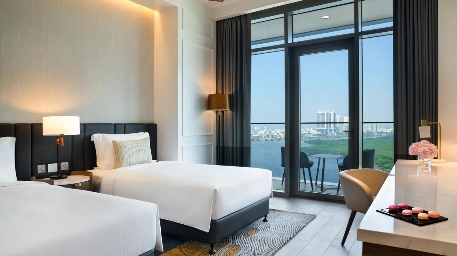 une chambre d'hÃ´tel avec deux lits et un balcon au Rotana Ras Al Khaimah - The Mangroves Ã  Ras Al Khaimah