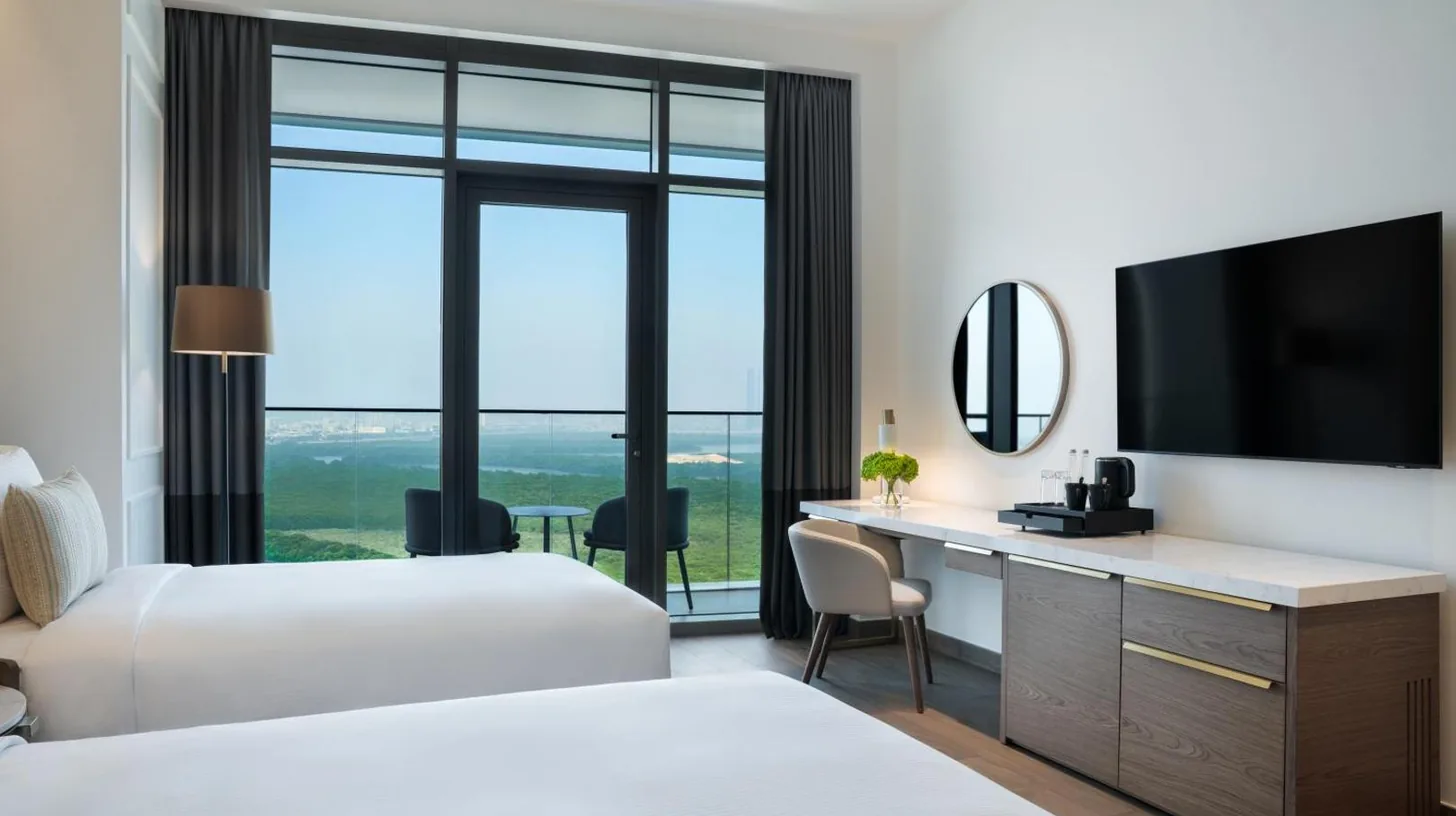 une chambre d'hÃ´tel avec deux lits et un bureau avec une tÃ©lÃ©vision au Rotana Ras Al Khaimah - The Mangroves Ã  Ras Al Khaimah