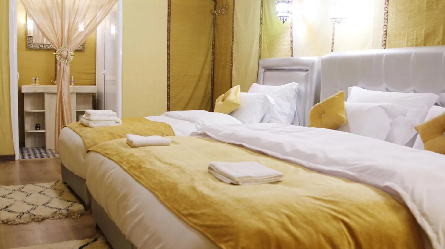 une chambre avec deux lits avec des serviettes dessus Ã  Sahara Sky Luxury Camp Ã  Merzouga