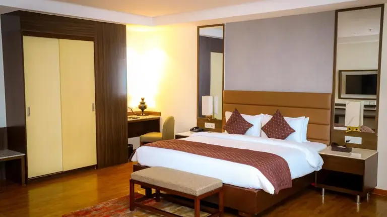 a hotel room with a large bed and a desk at Soaltee Westend Itahari in Itahari