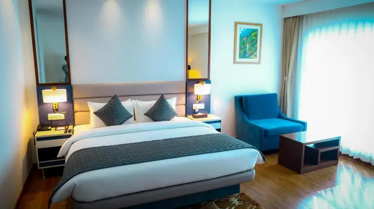 a bedroom with a large bed with blue pillows at Soaltee Westend Itahari in Itahari