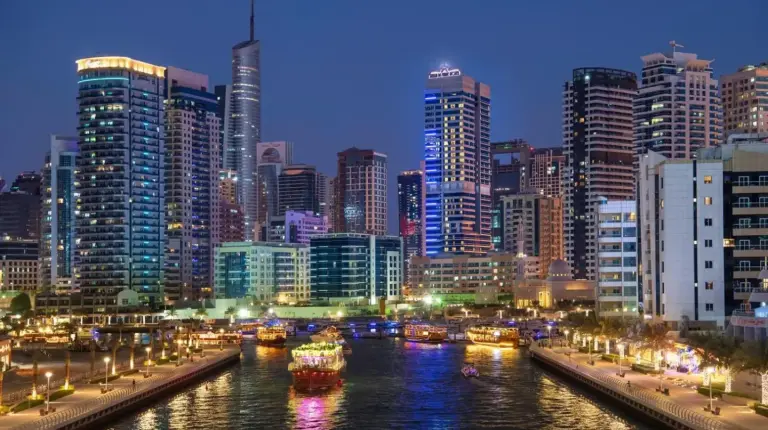 a city at night with boats in the water at Stella Di Mare Dubai Marina Hotel in Dubai