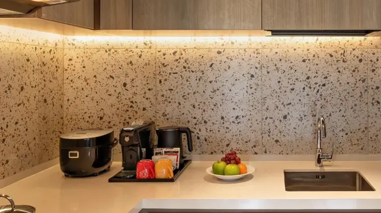 a kitchen with a sink and a bowl of fruit on a counter at Swissôtel Living Jakarta Mega Kuningan in Jakarta