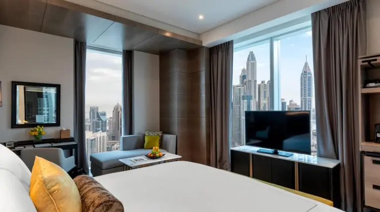 ein Hotelzimmer mit einem großen Bett und einem großen Fenster im Taj Jumeirah Lakes Towers in Dubai
