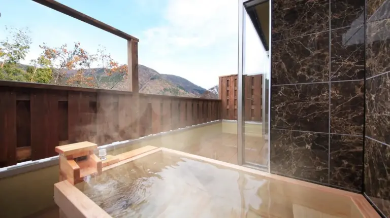 une salle de bain avec une baignoire et une grande fenÃªtre Ã  Tensui Saryo Ã  Hakone
