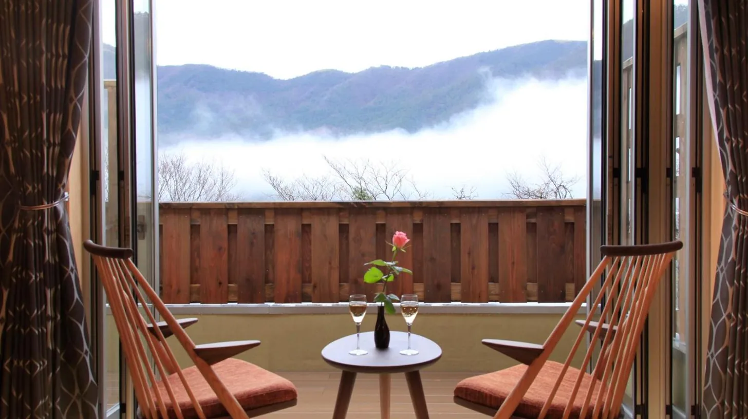 une table avec deux chaises et un vase avec une fleur sur un balcon Ã  Tensui Saryo Ã  Hakone