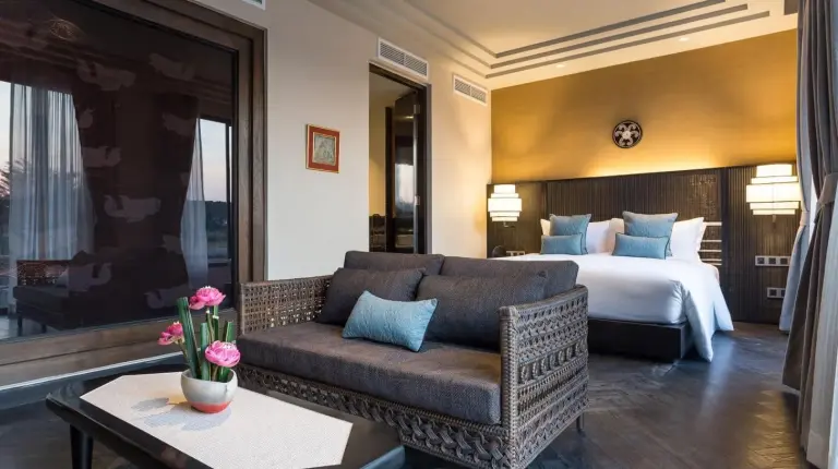 une chambre d'hÃ´tel avec un canapÃ© et un lit Ã  THANN Wellness Destination Ã  Phra Nakhon Si Ayutthaya