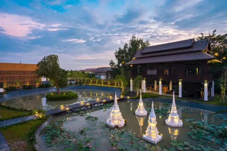 Vue extÃ©rieure de THANN Wellness Destination avec un Ã©tang paisible et l'architecture