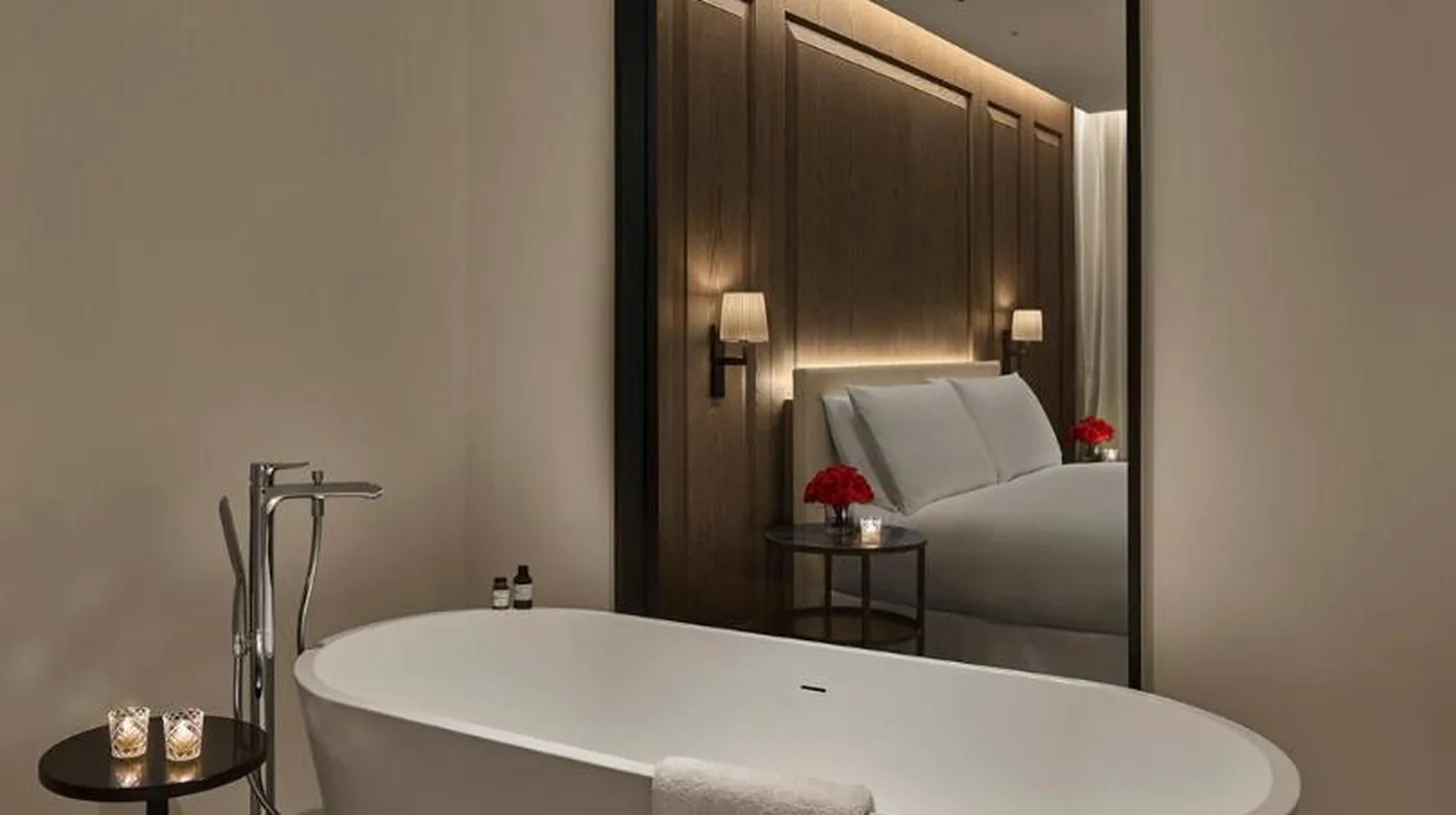 eine weiÃe Badewanne in einem Badezimmer mit Spiegel im The Abu Dhabi EDITION in Abu Dhabi