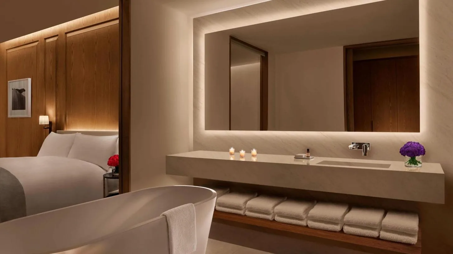 ein Badezimmer mit Badewanne, Waschbecken und Bett im The Abu Dhabi EDITION in Abu Dhabi