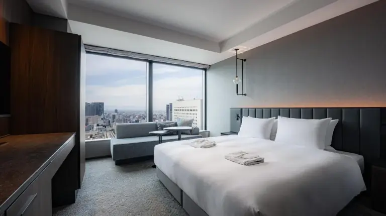 a hotel room with a bed and a large window at The Gate Hotel Osaka by Hulic in Osaka