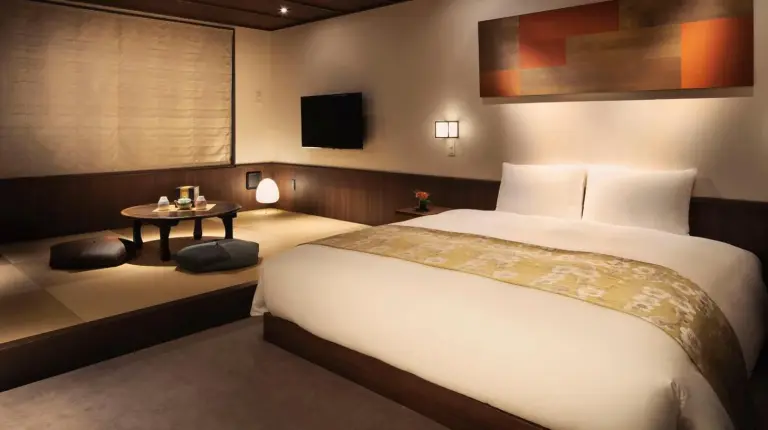 a bedroom with a large bed and a table at THE JUNEI HOTEL Kyoto Imperial Palace West in Kyoto