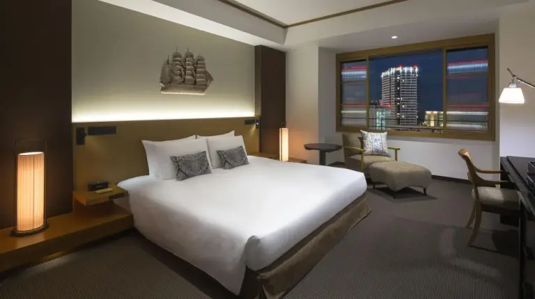 a hotel room with a large bed and a desk at The ORIENT in Kobe
