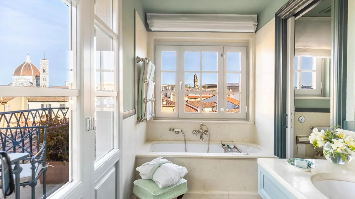 a bathroom with a tub and a sink and a window at The Place Firenze in Florence