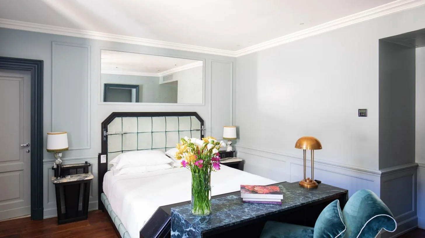 a bedroom with a bed with a vase of flowers on a table at The Place Firenze in Florence
