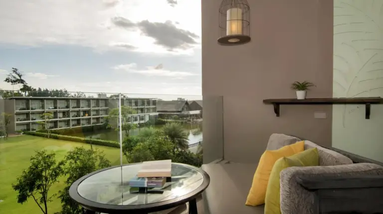a living room with a glass table and a window at The Sands Khao Lak by Katathani - SHA Extra Plus in Khao Lak
