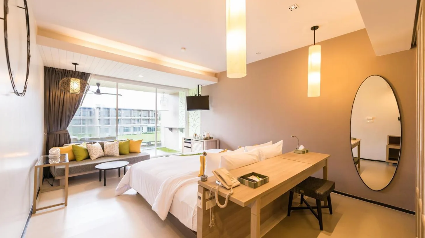 a bedroom with a bed and a desk and a mirror at The Sands Khao Lak by Katathani - SHA Extra Plus in Khao Lak