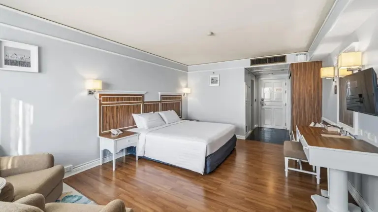una habitaciÃ³n de hotel con una cama y una sala de estar en Town in Town Hotel Bangkok en Bangkok