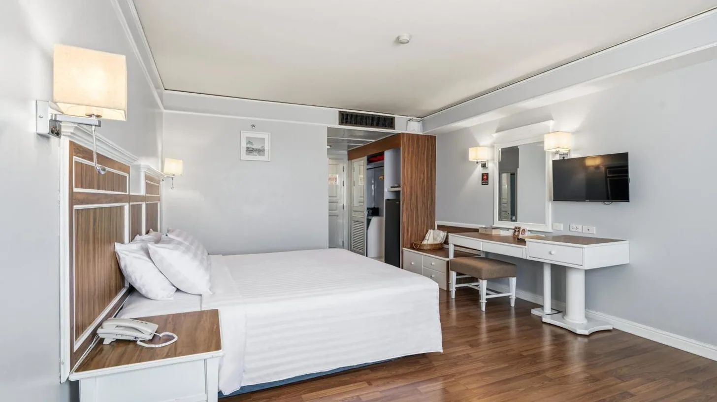 una habitaciÃ³n de hotel con una cama blanca y un escritorio en Town in Town Hotel Bangkok en Bangkok