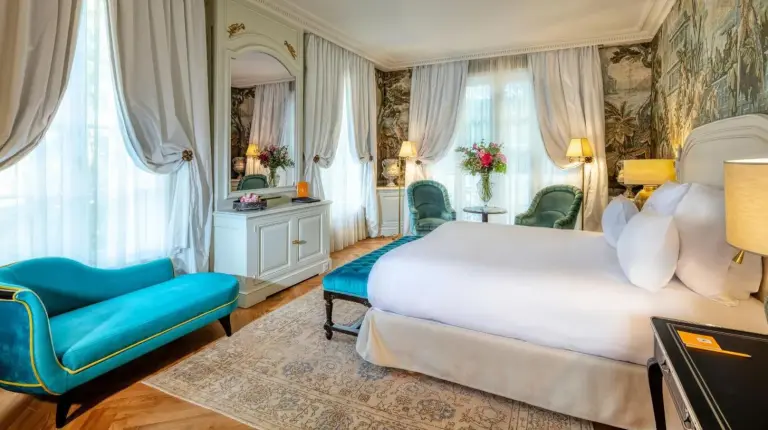 a bedroom with a large bed and a blue chair at Villa Saint-Ange in Aix-en-Provence