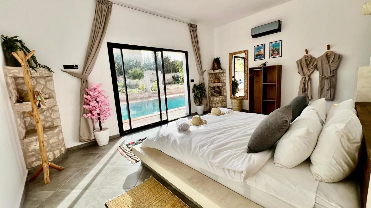 ein groÃes weiÃes Bett in einem Raum mit einem Fenster in der Villa Serinie in Essaouira