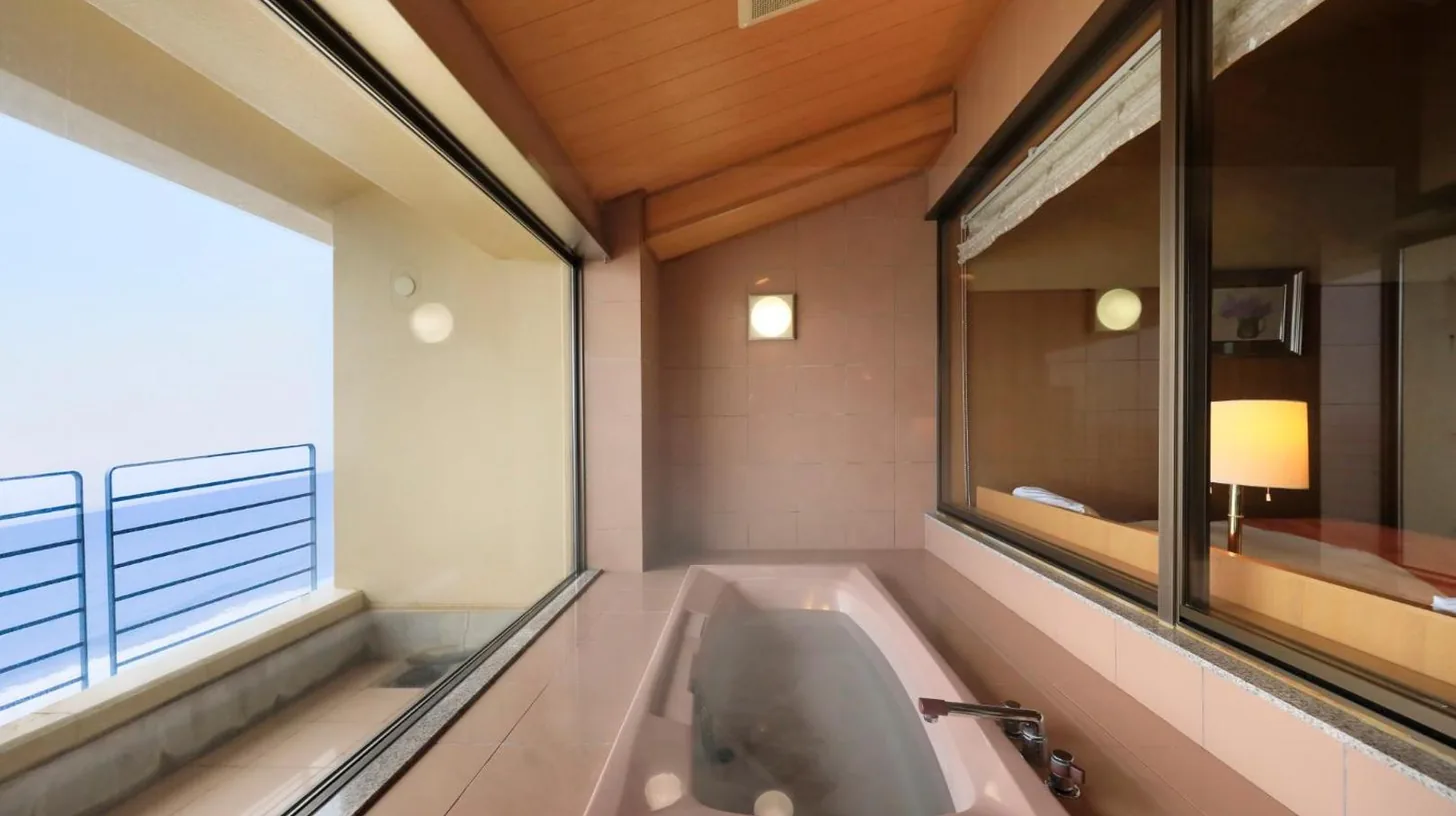une baignoire dans une salle de bain avec une fenÃªtre au Wakamatsu Hot Spring Resort Ã  Hakodate